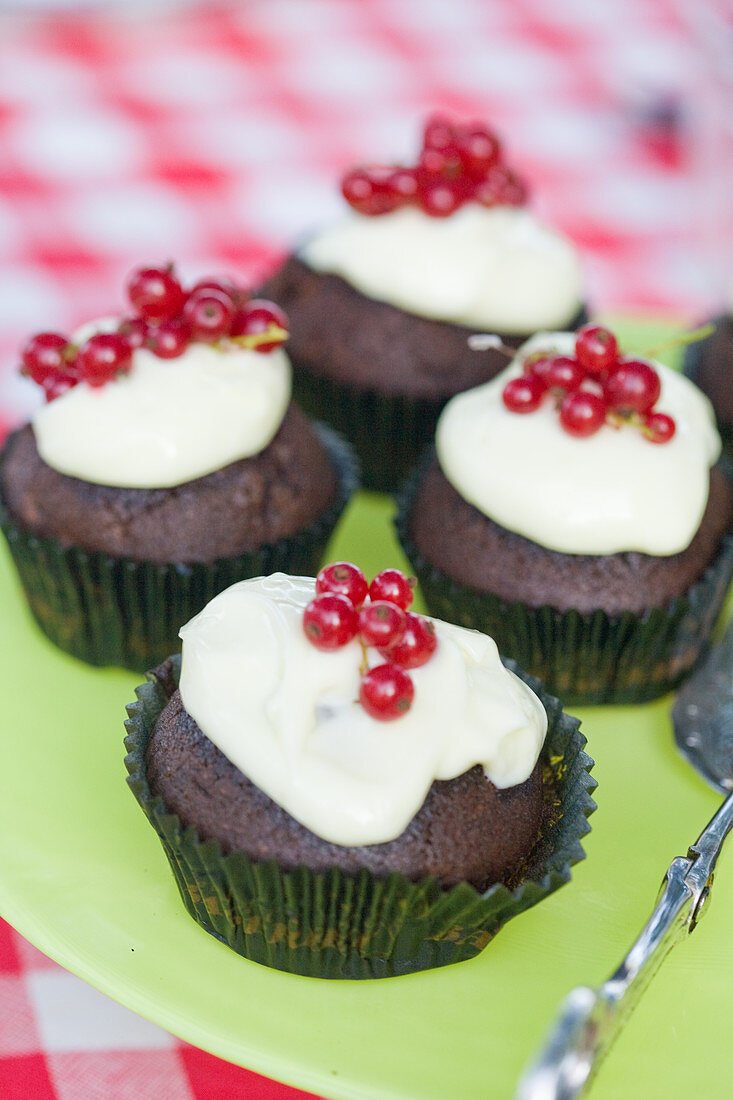 Schokoladenmuffins mit Frischkäse-Frosting und Johannisbeeren