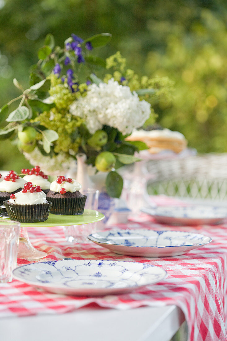 Flowers and place settings on summery garden table