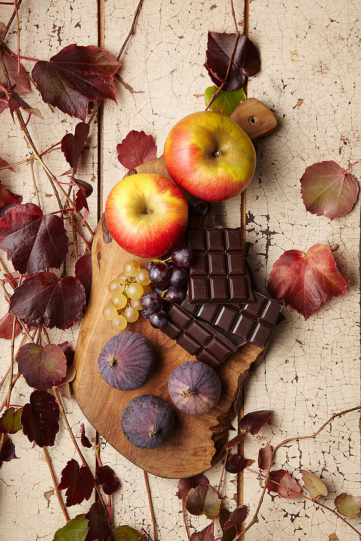 An autumnal arrangement of apples, figs, grapes and chocolate