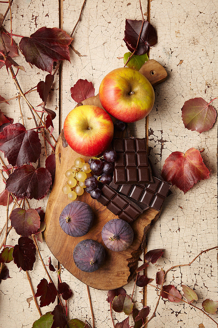 Herbstliches Stillleben mit Äpfeln, Feigen, Weintrauben und Schokolade