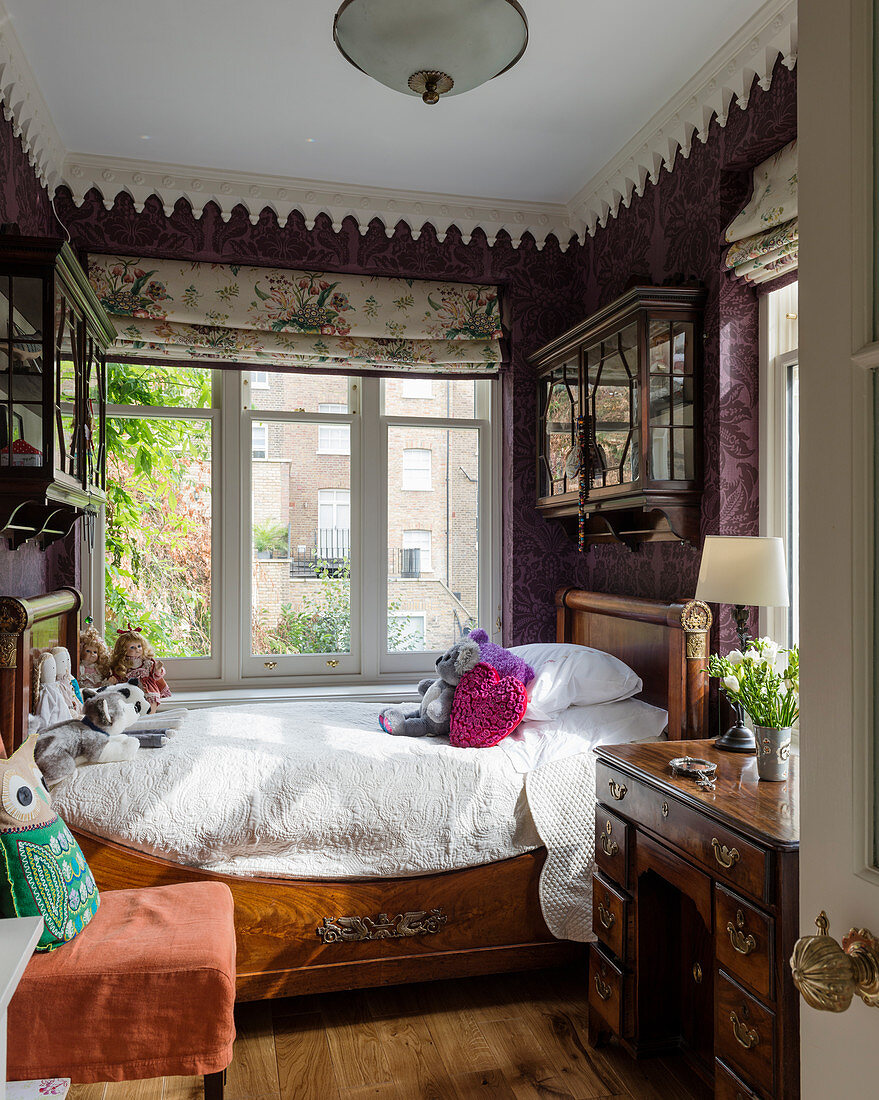 Antique wooden bed in small, English-style child's bedroom