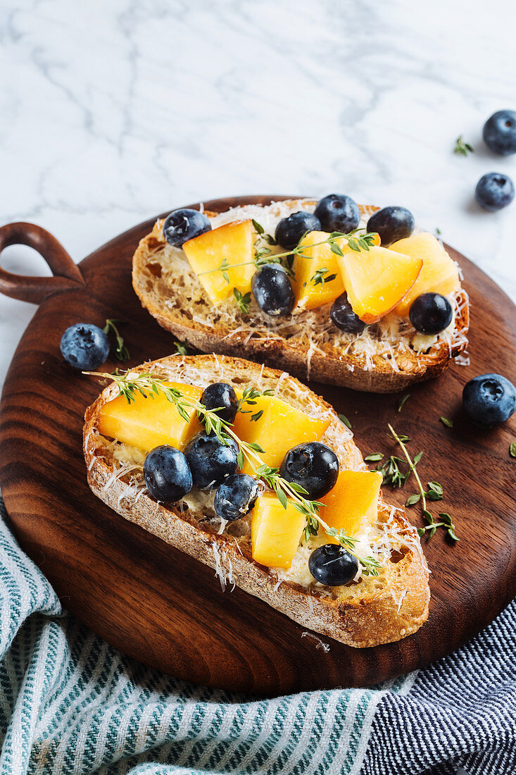 Sandwiches with homemade bread and fresh apricot and blueberries garnished with thyme