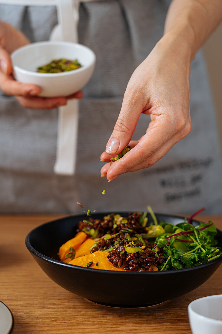 Veganen Salat mit Samen bestreuen