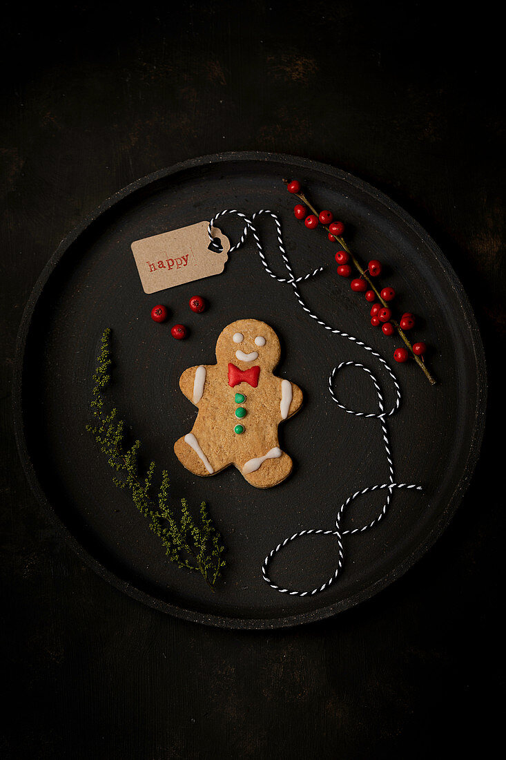 Christmas gingerbread cookie placed on tray with holiday decorations