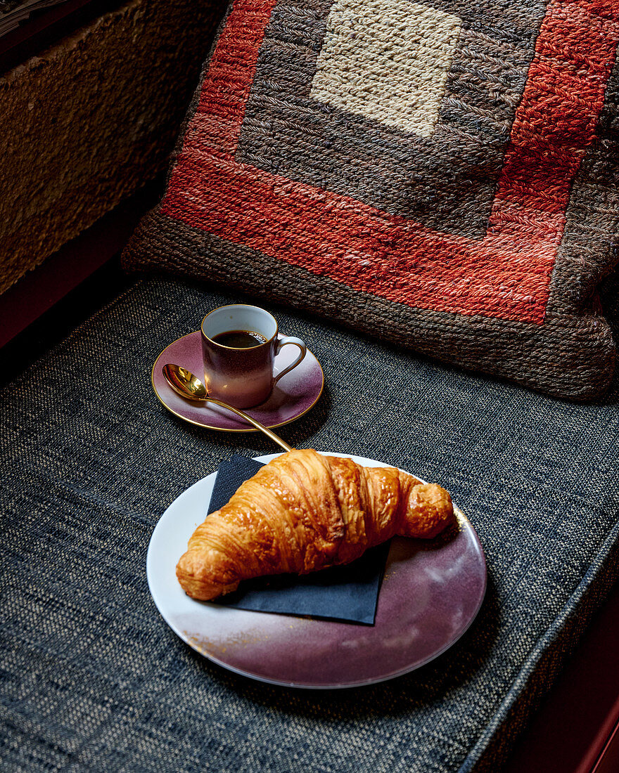 Croissant on a plate with an espresso