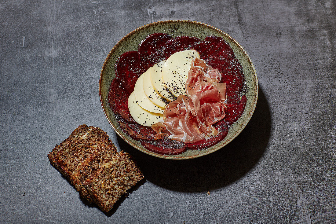 Rote-Bete-Carpaccio mit Scamorza, geräuchterem Schinken und Mohn