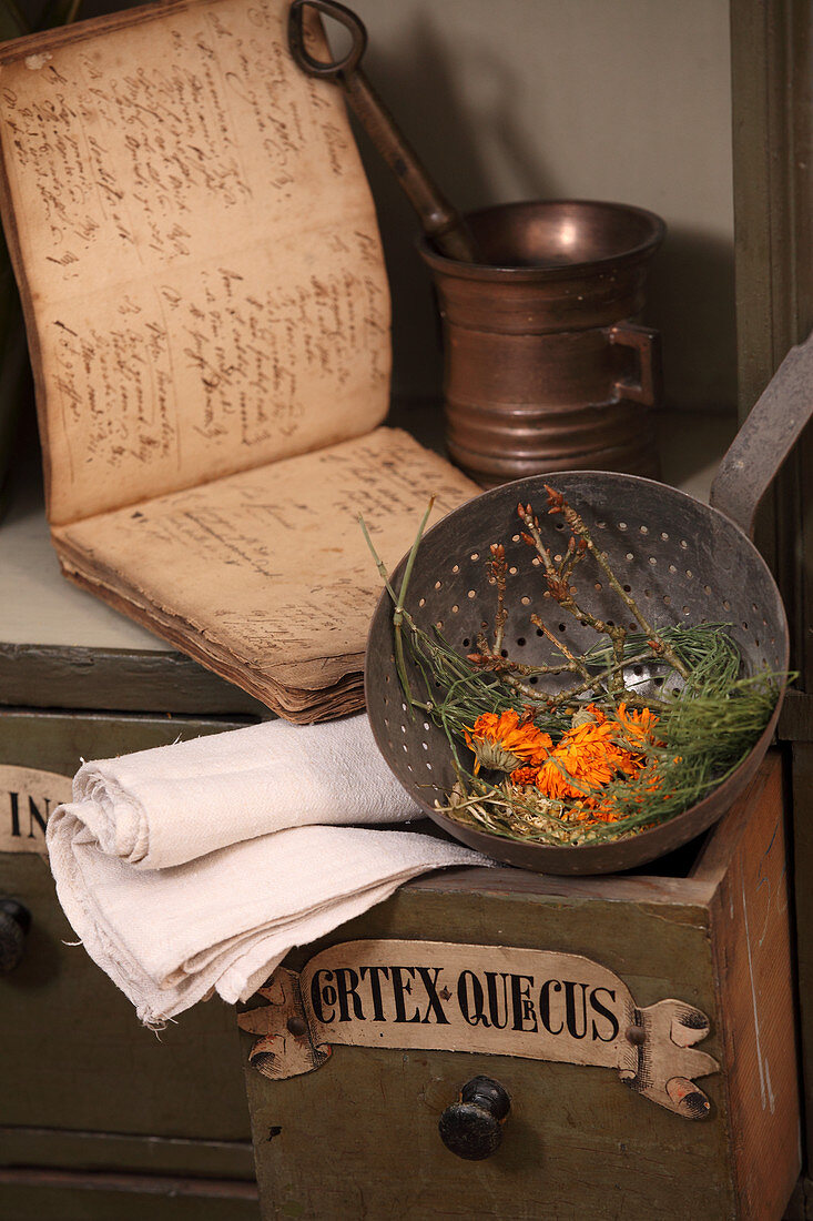 Marigolds and herbs in an antique metal sieve