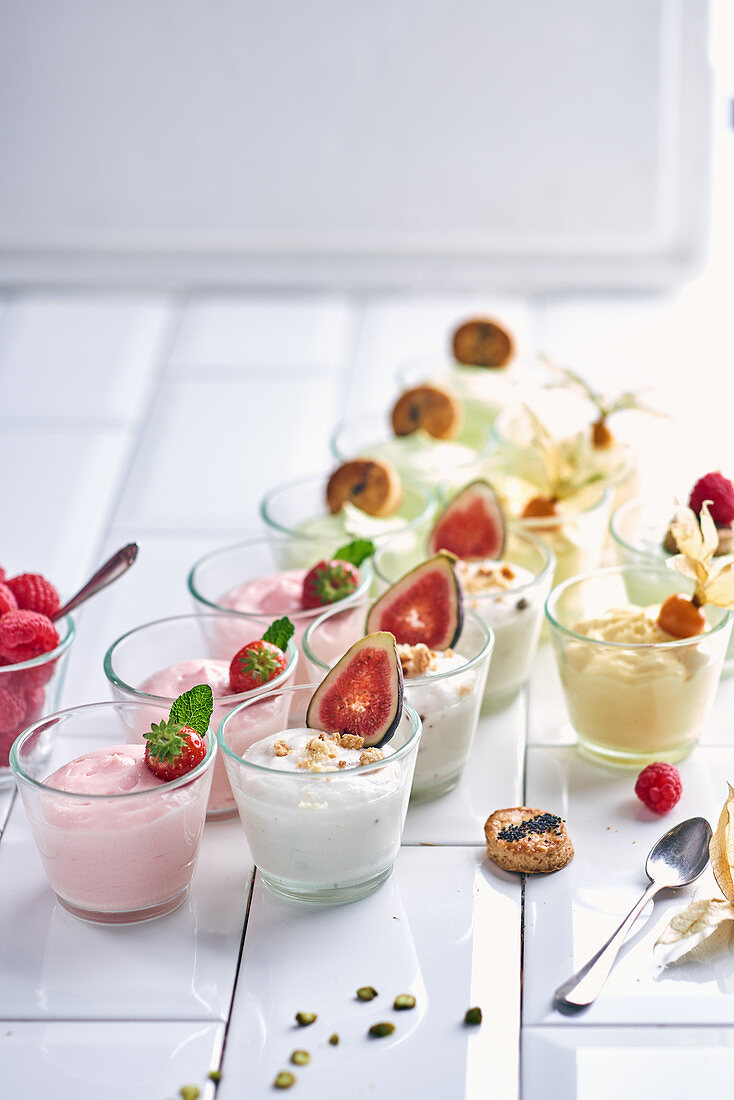 Various yoghurt desserts with fruit in small glasses