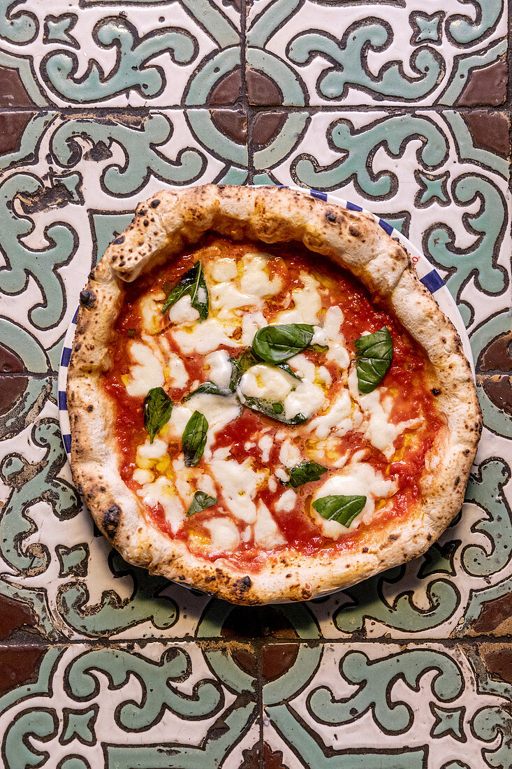 Pizza Margherita on colourful tiles