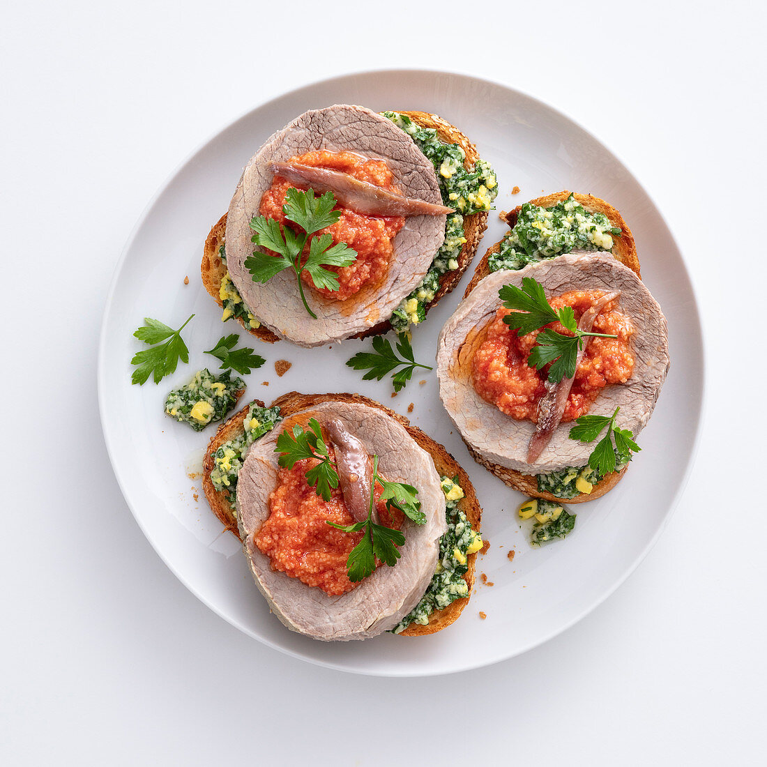 Crostini with boiled beef, green and red salsa and anchovies