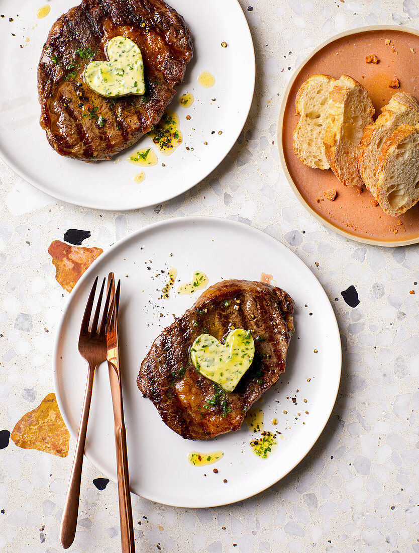 Grilled steaks topped with herb butter hearts