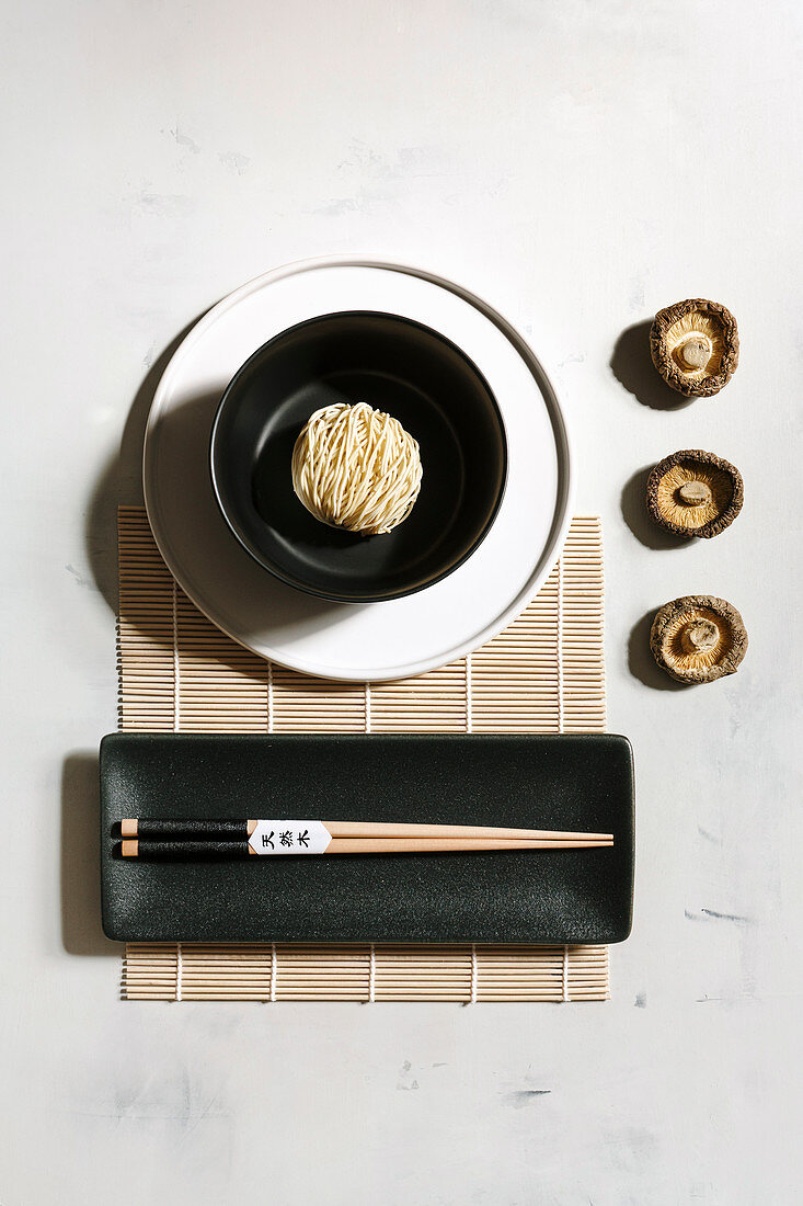 Dried noodles in a bowl, shiitake mushrooms and chopsticks