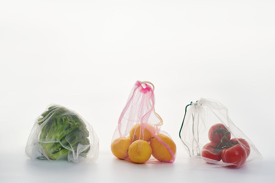 Food in net mesh bags on white background