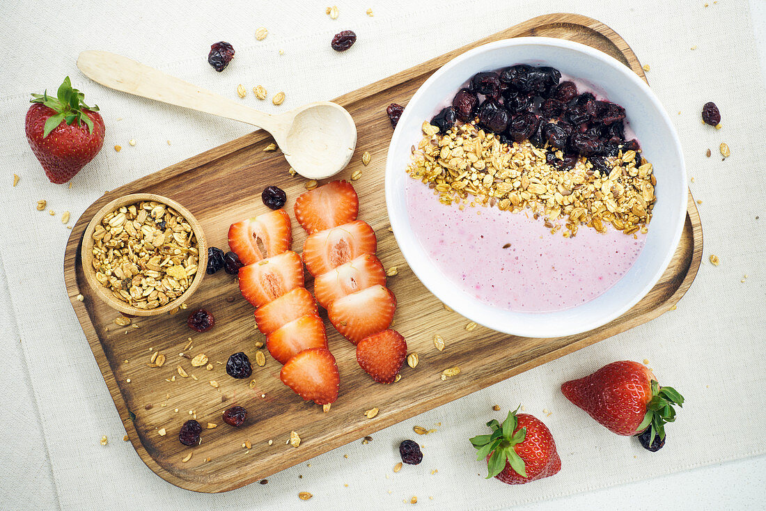 Oatmeal and dried berries with yogurt and fresh strawberries