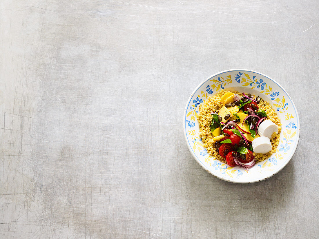 A healthy couscous salad with nectarines, vegetables and goat's cheese