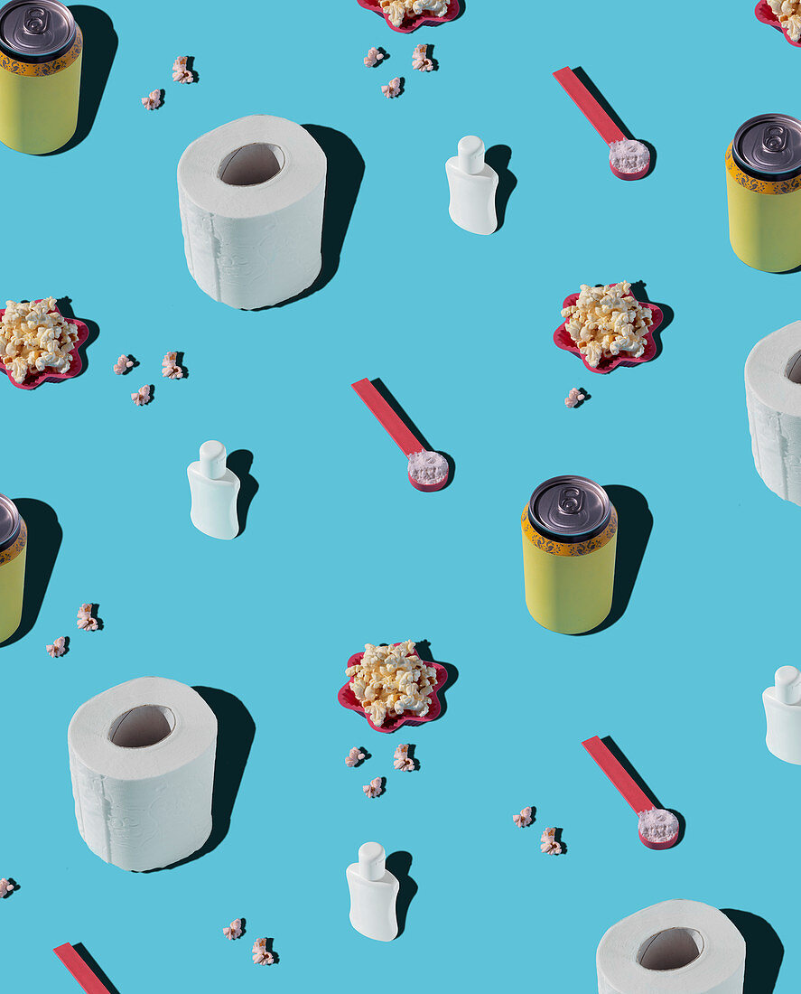 Patterns of hygiene supplies and soda cans on blue background with popcorn