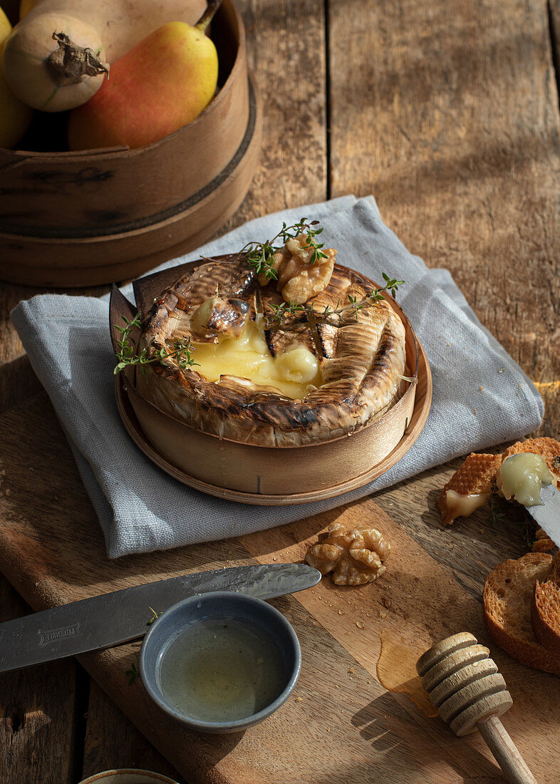 Gebackener Camembert mit Walnüssen auf Holztisch