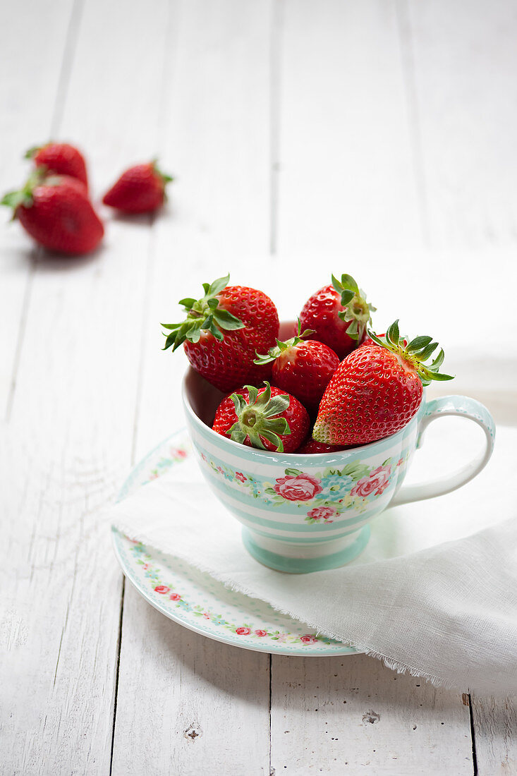 Fresh strawberries in porcelain cup