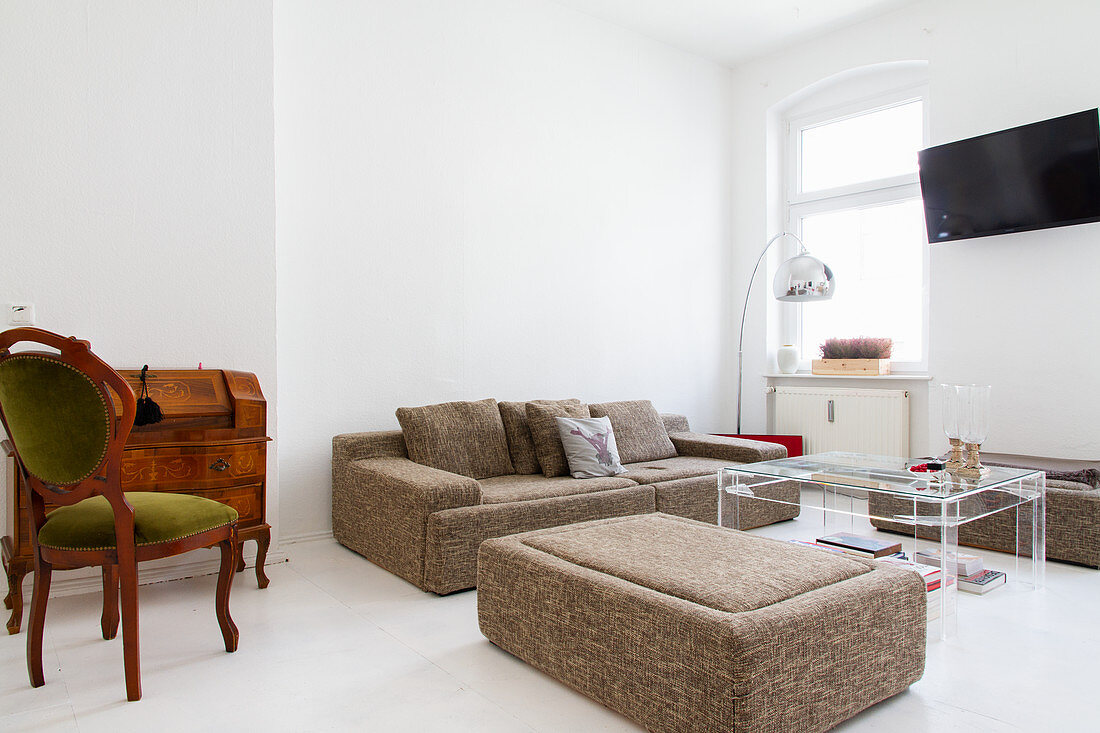 Gray sofa set, clear acrylic coffee table, secretary desk, and an antique chair in a white living room