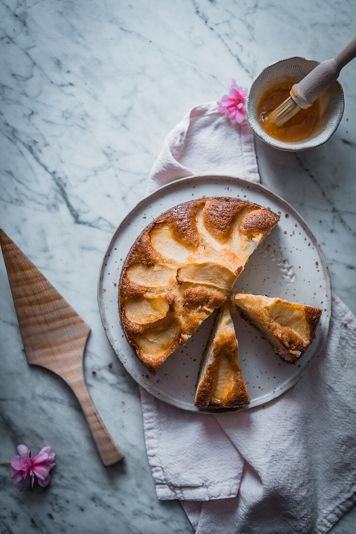 Apple cakes on plate, bowl with sweet syrup and cooking brush