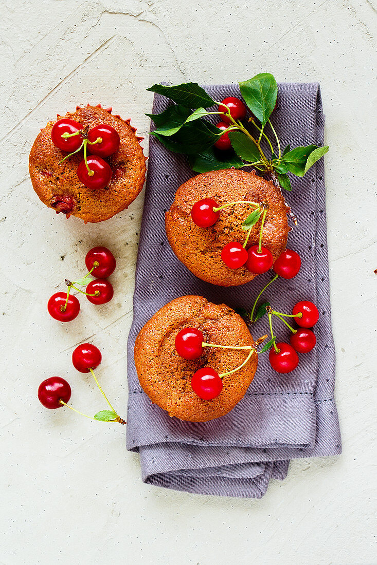Homemade cherry muffins with sweet cherry on concrete background