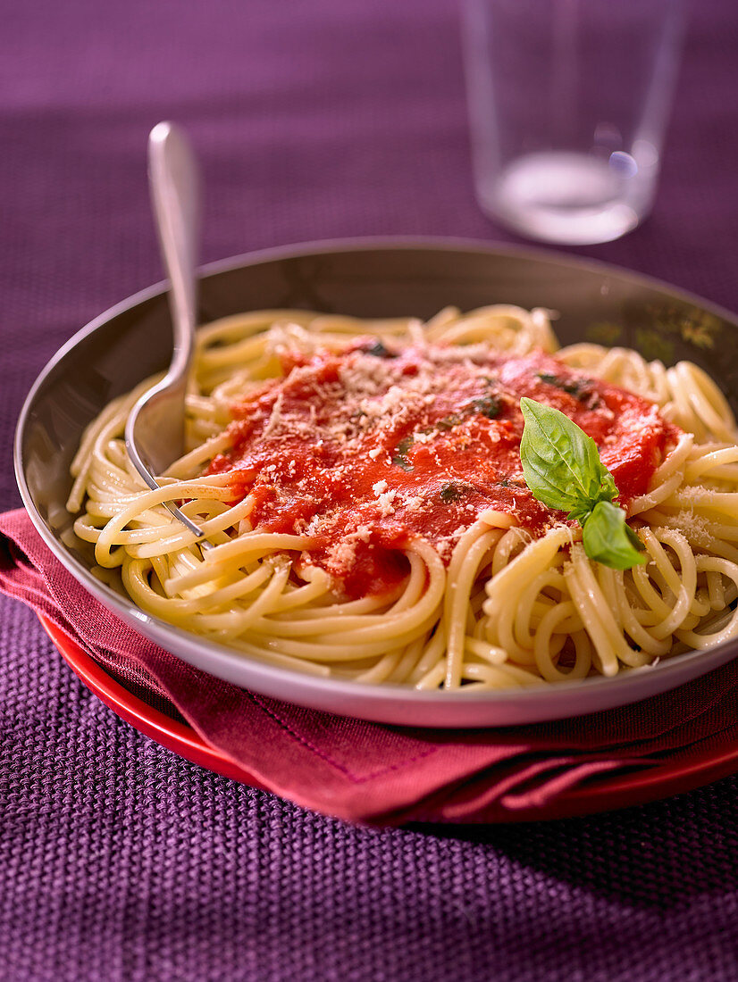 Spaghetti with tomato sauce and a basil leaf
