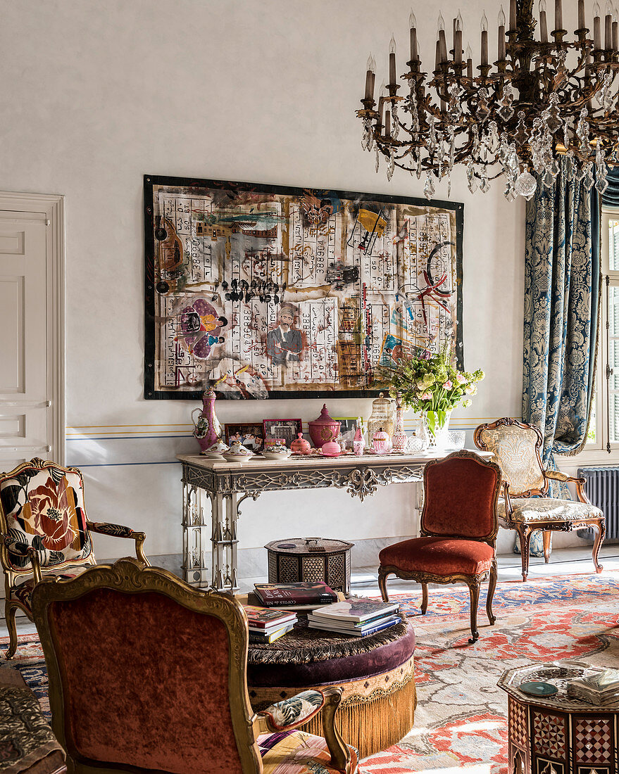 Collage above console table and Baroque chairs in living room