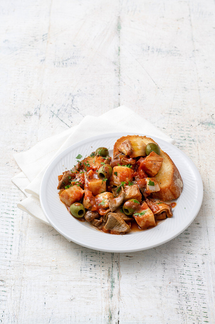 Stockfisch mit Steinpilzen und Oliven in Tomatensauce