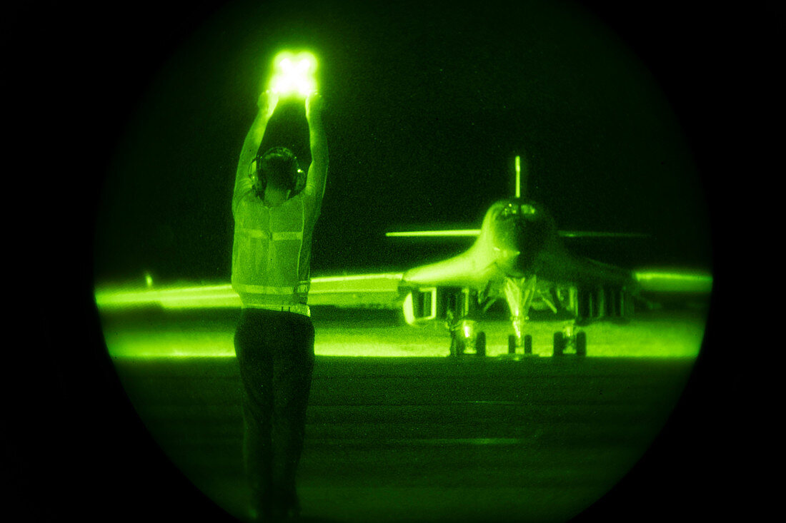 Guiding B-1B Lancer bomber on taxiway at night
