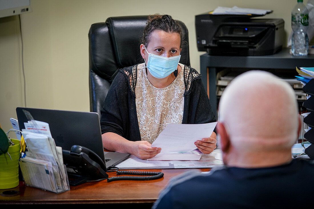 Man in consultation with a GP wearing a surgery mask