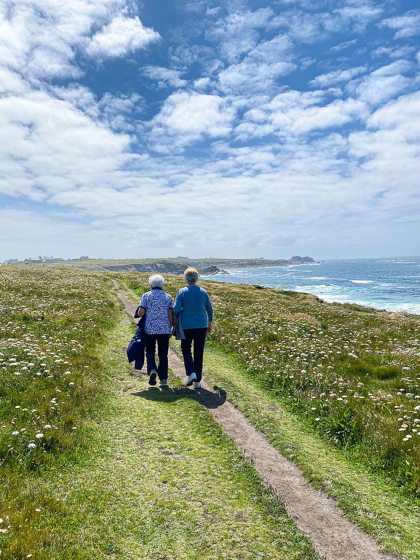 Elderly people walking by the sea