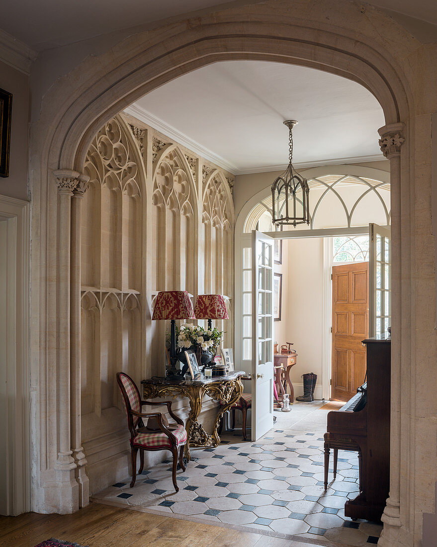 Foyer of historic villa with Gothic Revival stucco and archway