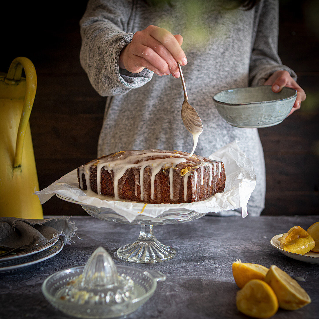 Lemon drizzle cake being glazed with icing