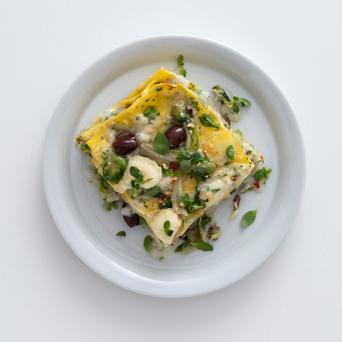 Lasagne with chicory, olives and anchovies on a plate