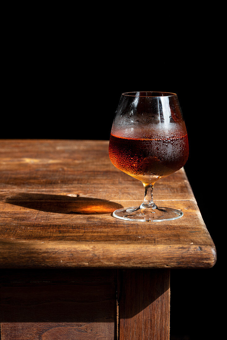 Glass of cognac with ice cubes