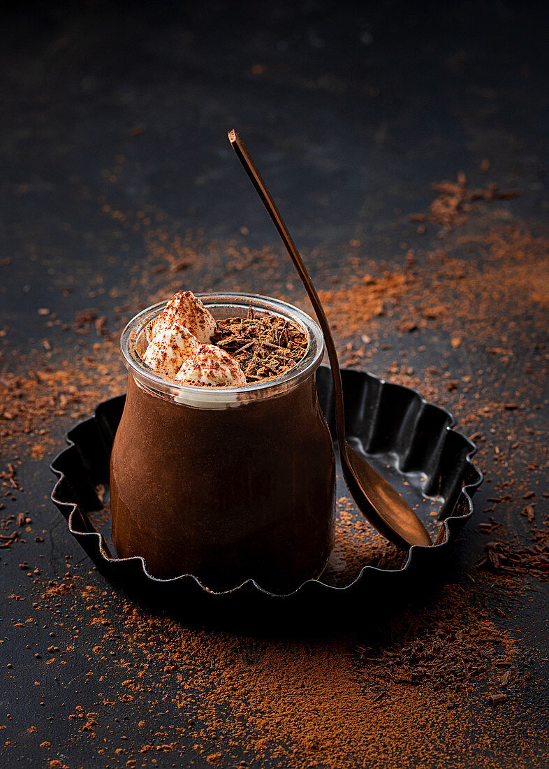 Chocolate mousse in glass jar with chocolate powder dust