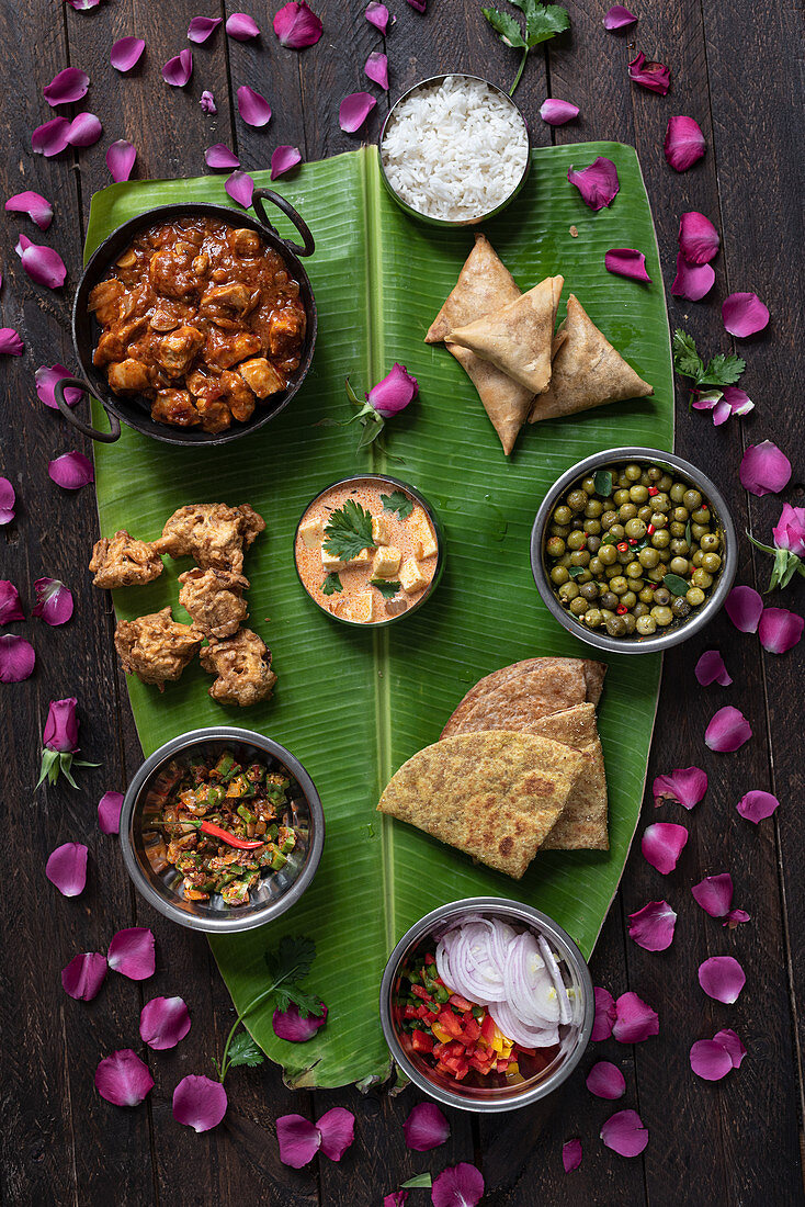 Verschiedene Gerichte der indischen Küche auf großem Bananenblatt