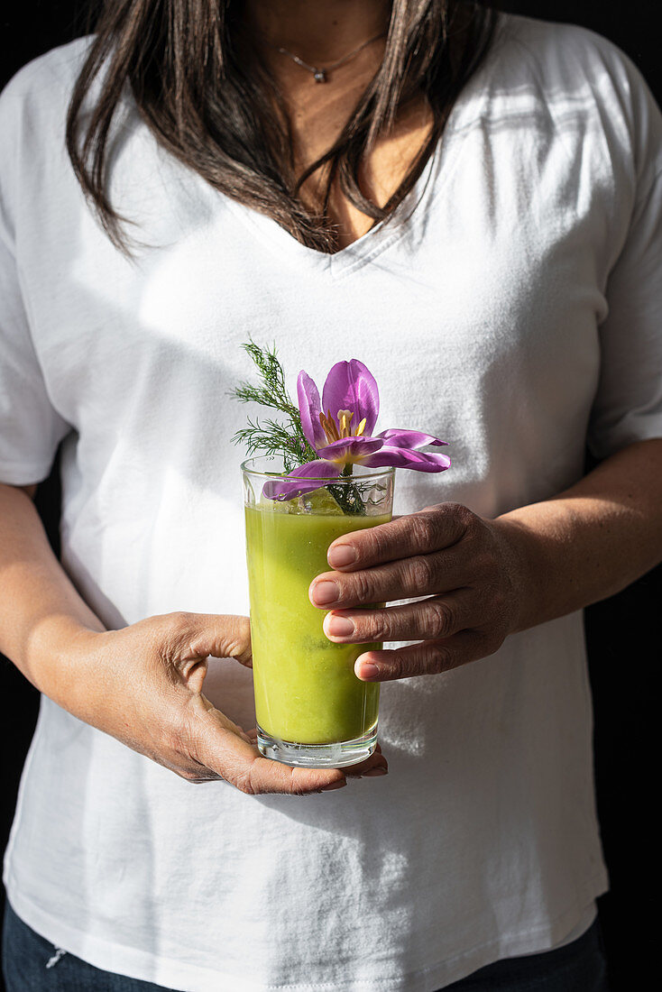 Female holds glass of green matcha drink