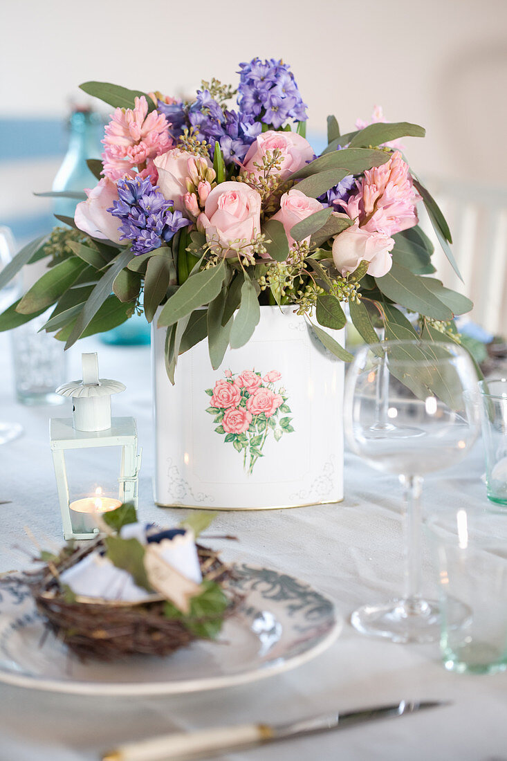 Bouquet with hyacinths, roses, and eucalyptus on a laid table
