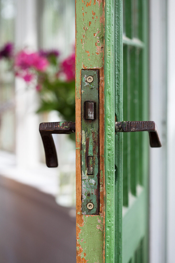 Battered green door with old door handles