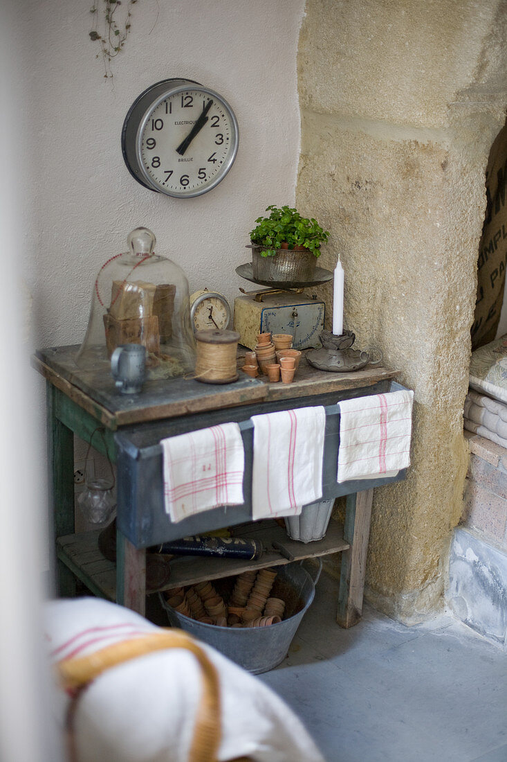 Wall clock above an old table with junk and flea market finds