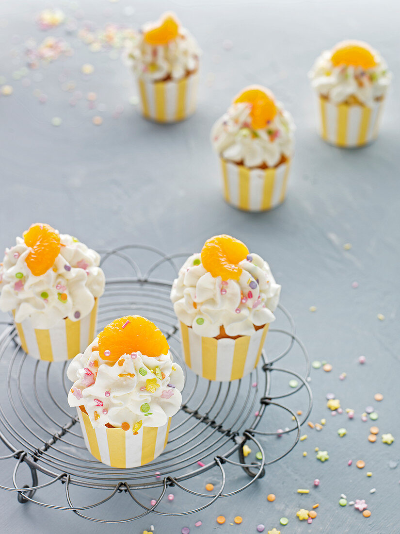 Käsesahne-Cupcakes mit Mandarine und bunten Zuckerstreuseln