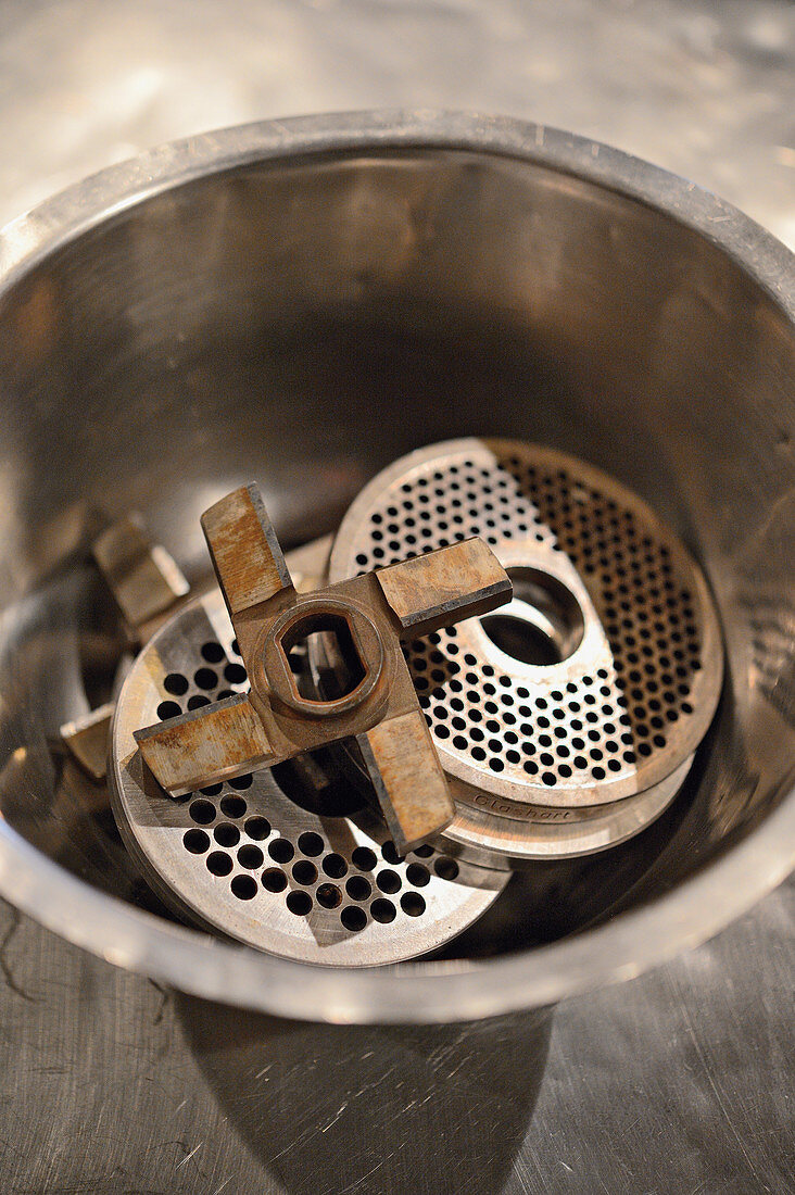 Sausages being made: mincer inserts in a metal bowl