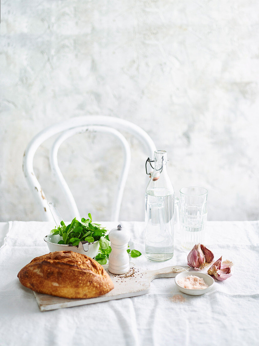 Brot, Salat, Wasser und Gewürze auf Tisch