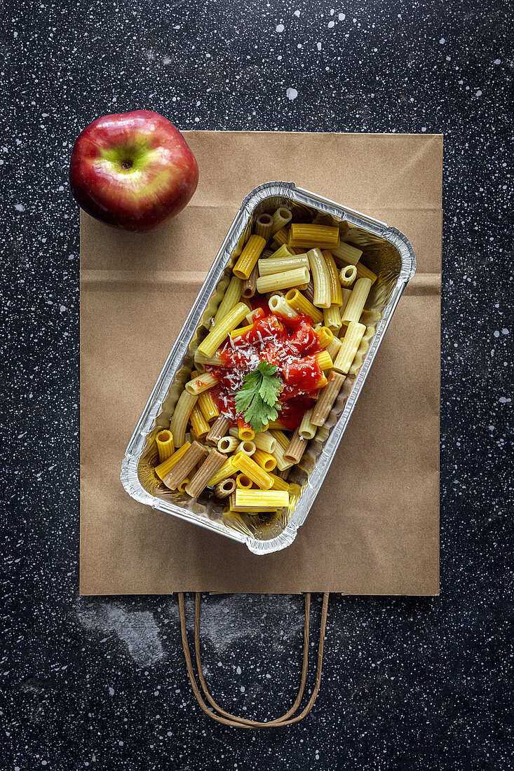 Macaroni with ketchup and cheese in container for takeaway