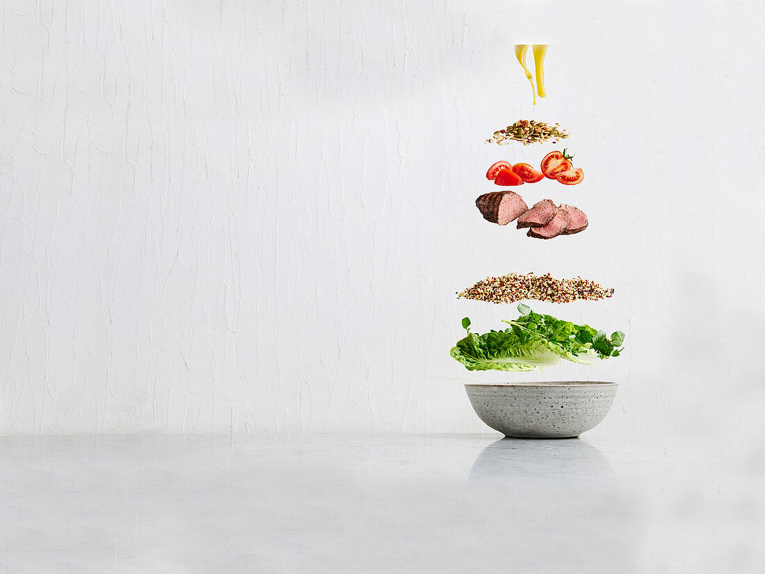 Salad ingredients floating over bowl