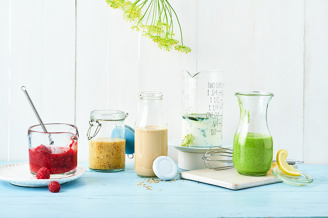 Verschiedene Salatdressings in Gläsern und Flaschen