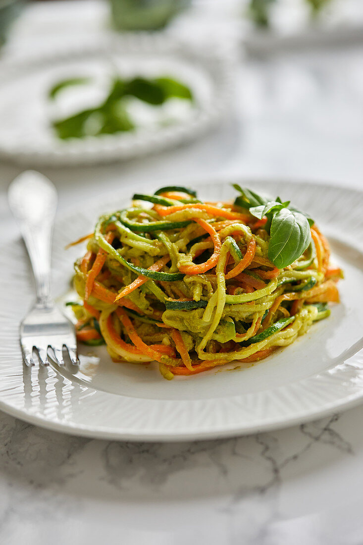Raw zucchini and carrot noodles with basil pesto sauce