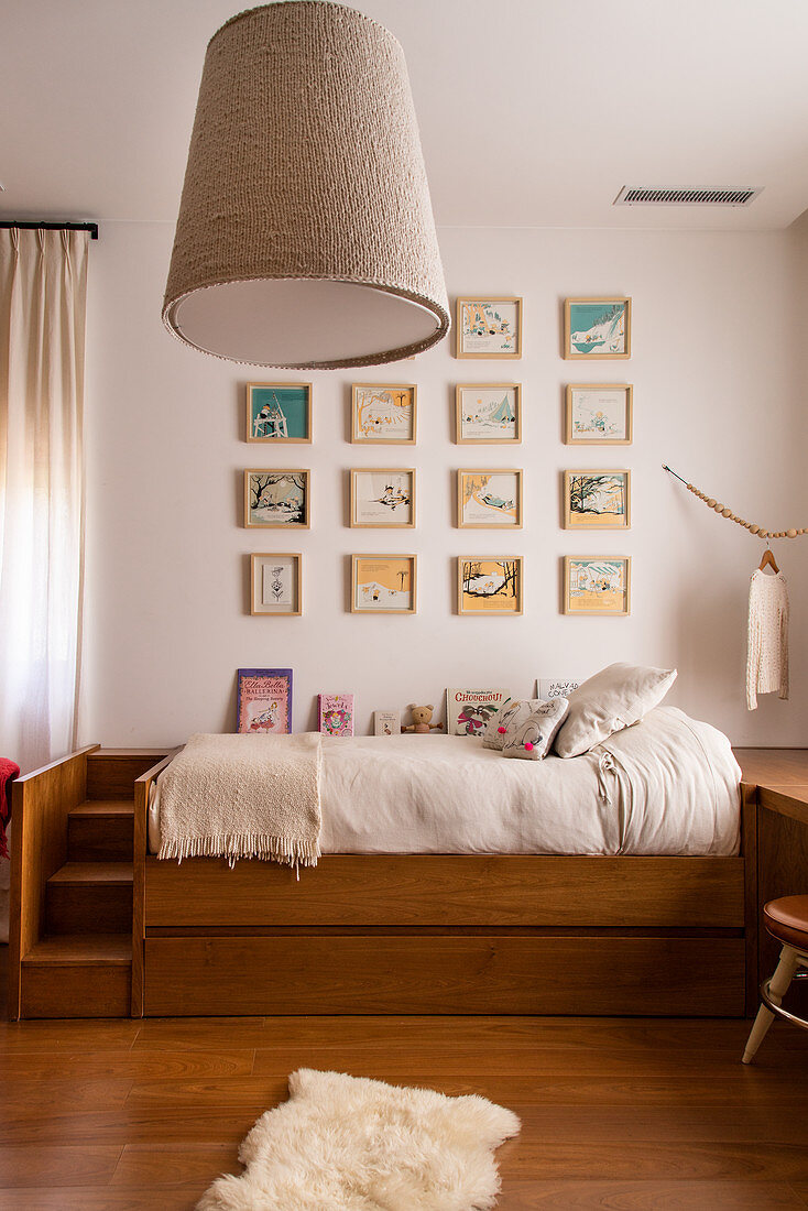 Gallery of pictures on wall above bed in child's bedroom decorated in shades of brown