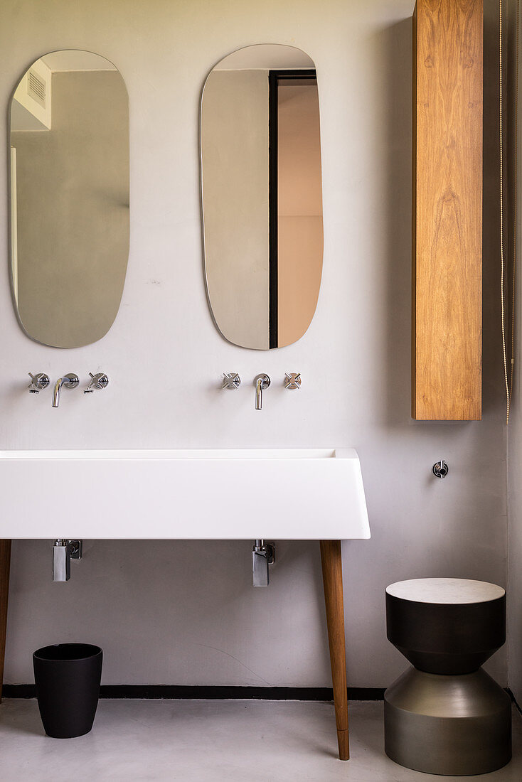 Organisch geformte Spiegel überm Waschbecken auf Möbelfüßen